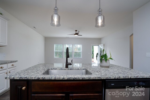 kitchen featuring dishwasher, light stone counters, a kitchen island with sink, sink, and white cabinetry