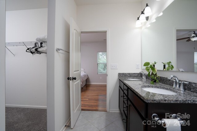 bathroom with tile patterned flooring, vanity, and ceiling fan