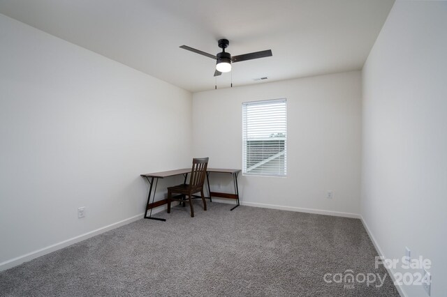 carpeted spare room with ceiling fan