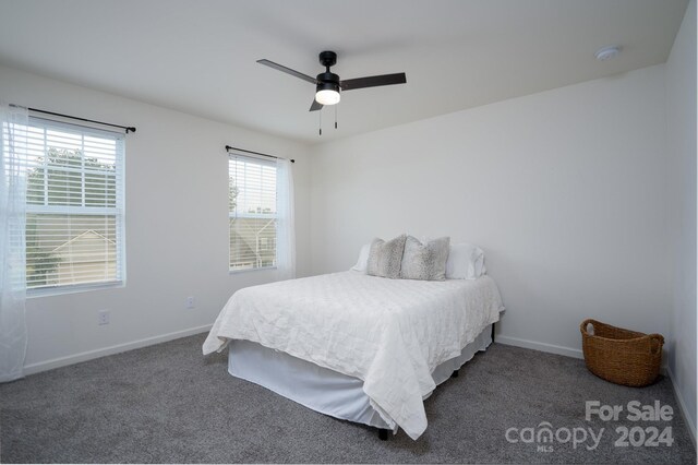 bedroom with ceiling fan and dark colored carpet