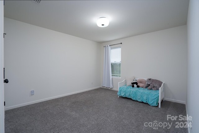 unfurnished room with dark carpet