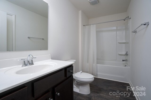 full bathroom with wood-type flooring, vanity, shower / tub combo, and toilet