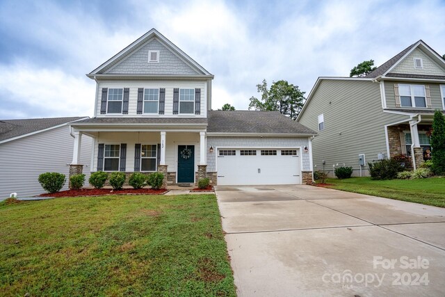 craftsman-style home featuring a porch, a garage, and a front yard