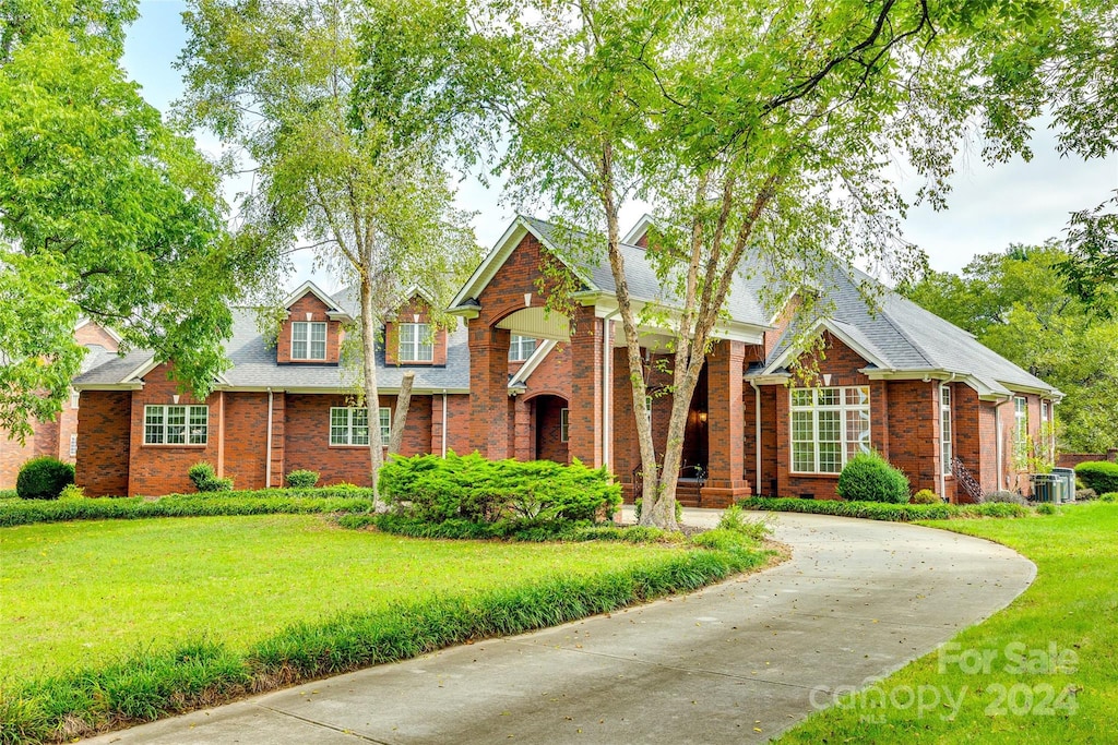 view of front of home featuring central AC unit and a front yard