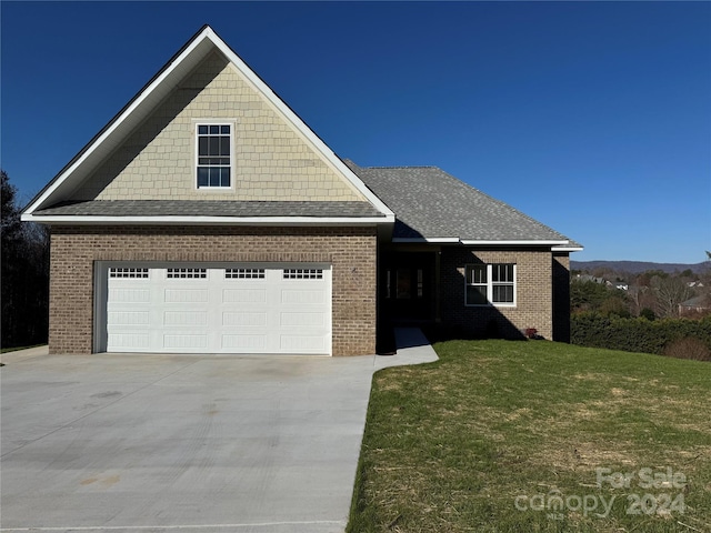 view of front of property featuring a front yard and a garage