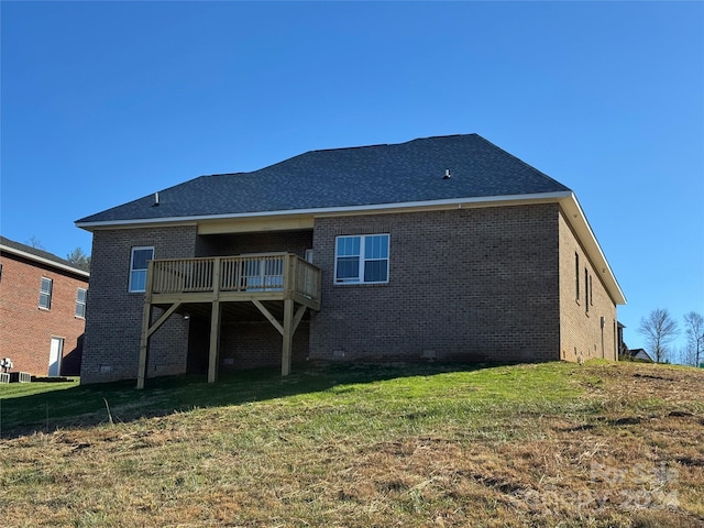 rear view of property featuring a lawn and a deck