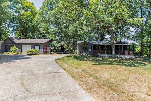 ranch-style house with covered porch, a front yard, and a garage