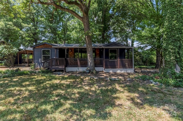 back of house featuring a lawn and a wooden deck