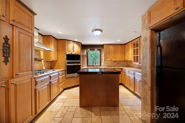 kitchen featuring sink, a kitchen island, backsplash, wall chimney range hood, and stainless steel appliances