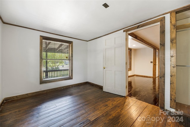 interior space with dark hardwood / wood-style floors and crown molding