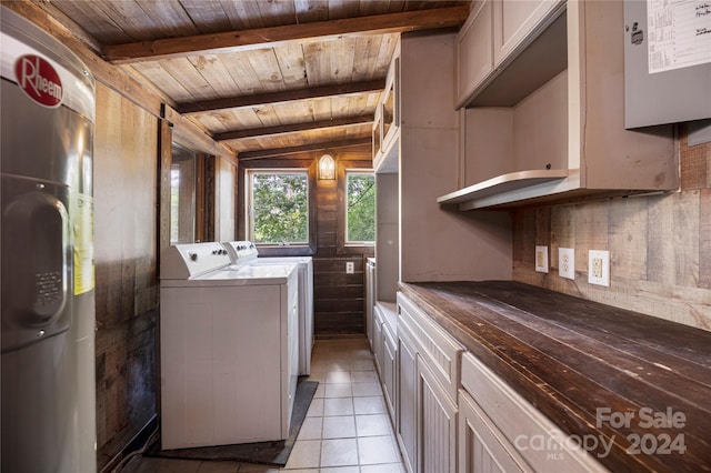 washroom with wood ceiling, wood walls, light tile patterned floors, and washing machine and dryer