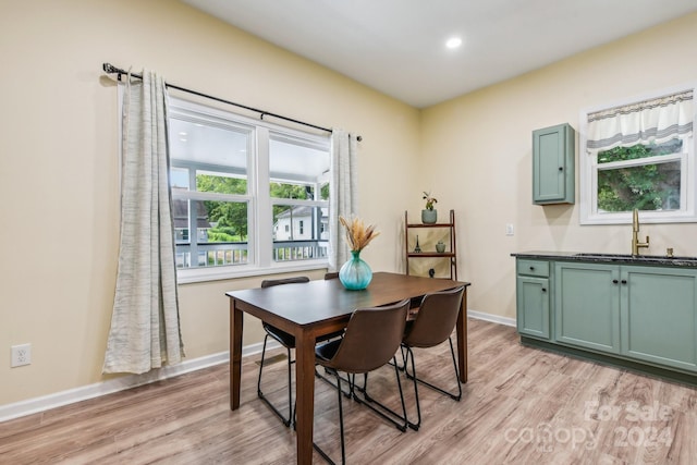 dining space with light wood-type flooring and sink