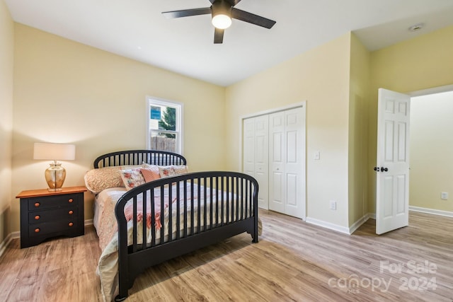 bedroom with light wood-type flooring, ceiling fan, and a closet