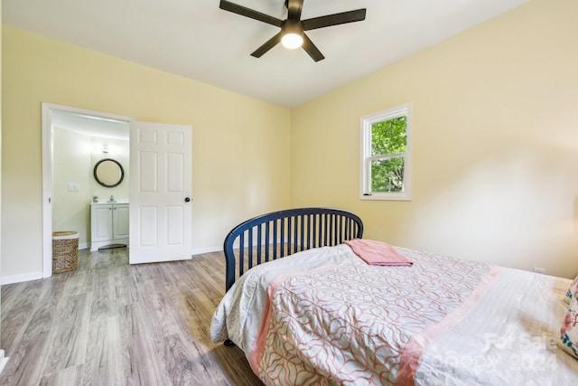 bedroom with light wood-type flooring, ceiling fan, and ensuite bathroom