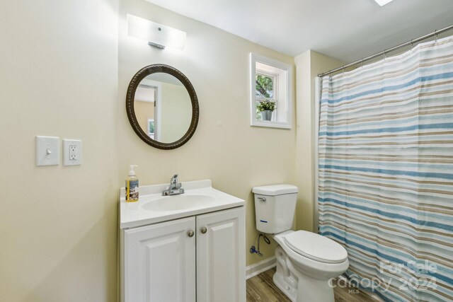 bathroom with walk in shower, vanity, toilet, and hardwood / wood-style flooring