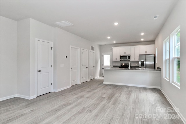 kitchen featuring stainless steel appliances, white cabinetry, and light wood-type flooring