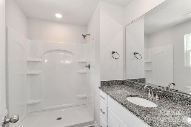 bathroom featuring a shower, vanity, and toilet