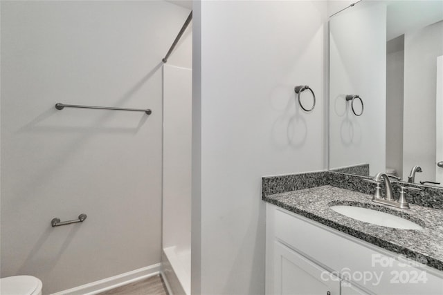 bathroom featuring walk in shower, vanity, toilet, and hardwood / wood-style flooring