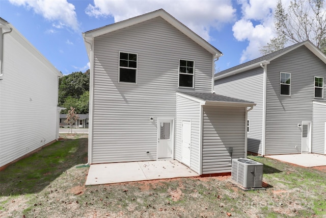 rear view of property with central AC unit and a patio