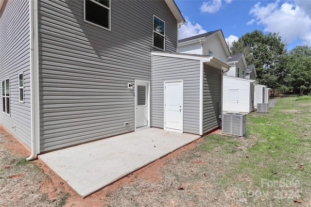 rear view of property featuring a lawn, a patio, and central AC unit