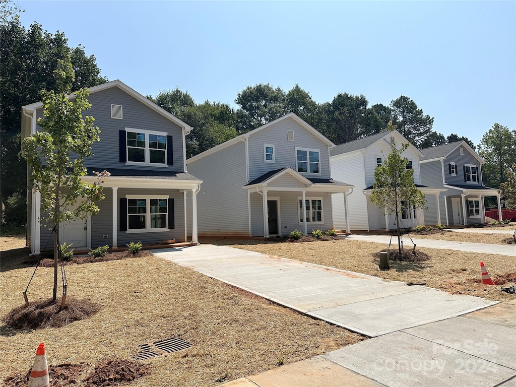 view of property with a porch and a garage