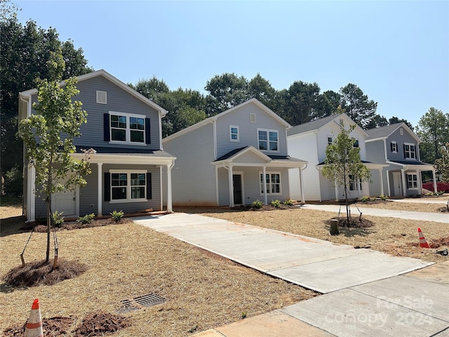 view of property with a porch and a garage