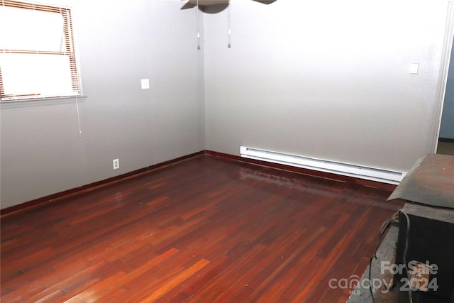 empty room featuring ceiling fan, baseboard heating, and hardwood / wood-style flooring