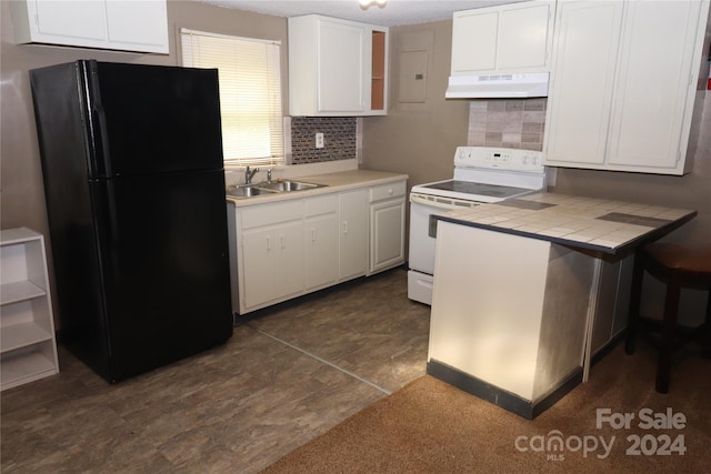 kitchen with black fridge, sink, decorative backsplash, tile countertops, and white range with electric stovetop