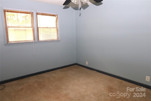 carpeted empty room featuring ceiling fan