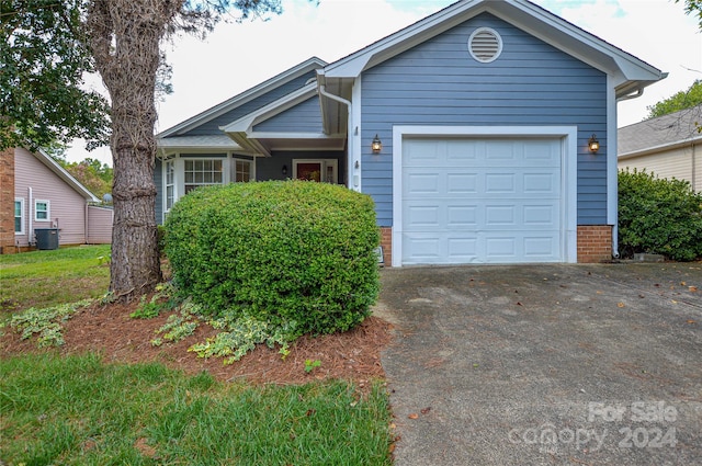 view of front of home featuring a garage and central air condition unit