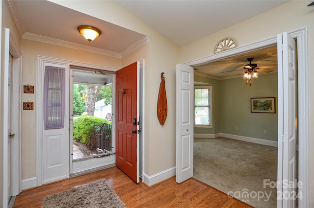 entrance foyer with light hardwood / wood-style flooring, ceiling fan, and crown molding