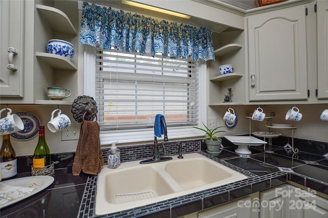 kitchen featuring white cabinets, tile countertops, and sink