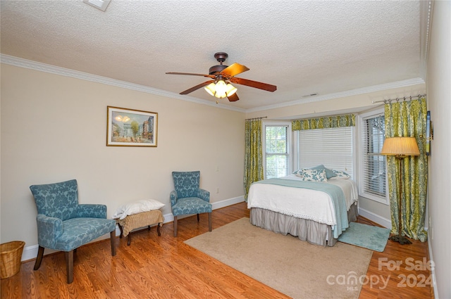 bedroom featuring ceiling fan, ornamental molding, and hardwood / wood-style floors