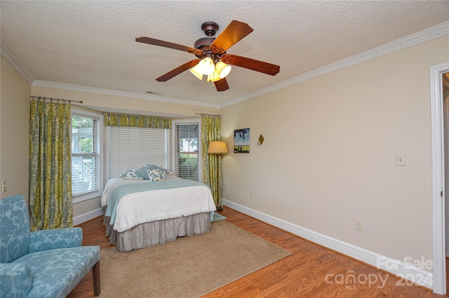 bedroom with ornamental molding, ceiling fan, hardwood / wood-style flooring, and a textured ceiling