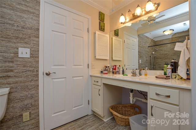 bathroom with ceiling fan, vanity, ornamental molding, hardwood / wood-style flooring, and toilet