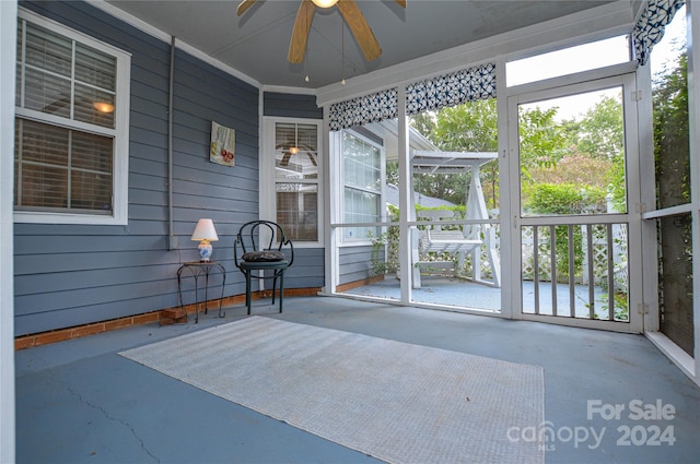 unfurnished sunroom featuring ceiling fan