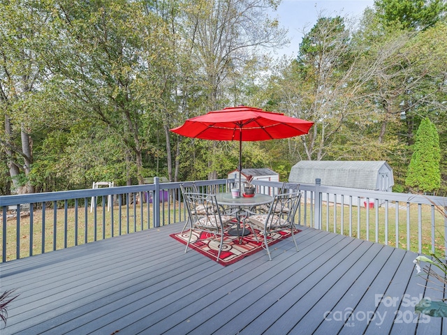 wooden terrace featuring a yard and a storage shed