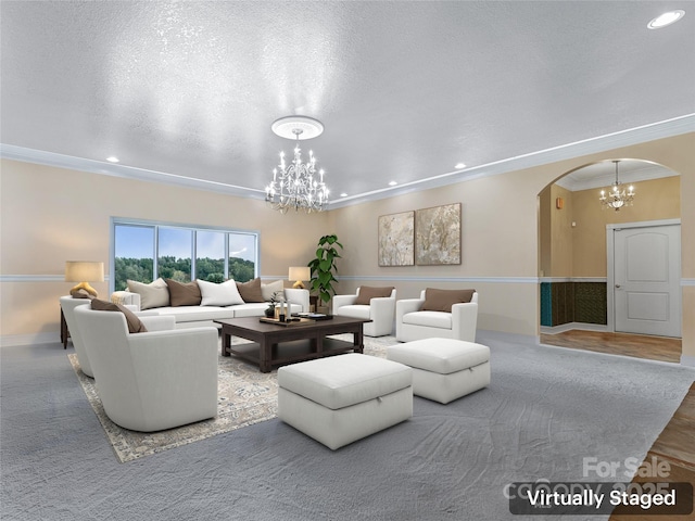 living room featuring arched walkways, crown molding, a notable chandelier, recessed lighting, and a textured ceiling