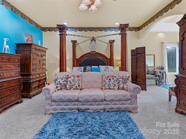 carpeted bedroom with arched walkways