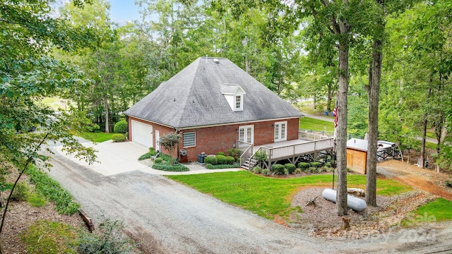 view of side of property with a lawn, a deck, and a garage