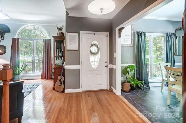 foyer featuring wood-type flooring and crown molding