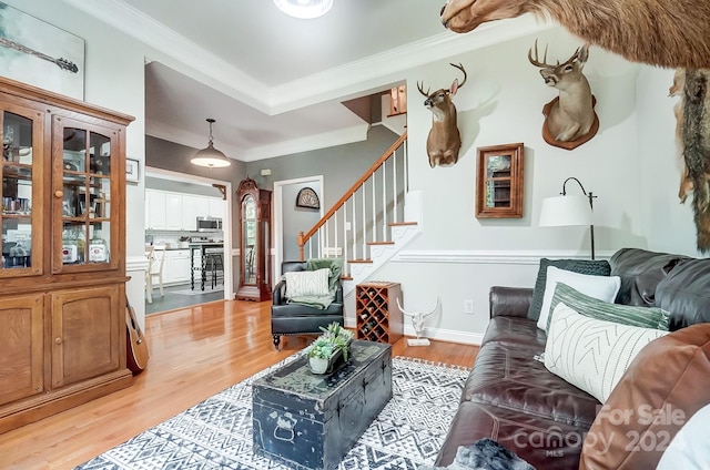 living room with light hardwood / wood-style flooring and ornamental molding