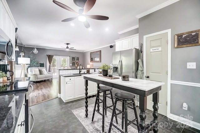 kitchen featuring white cabinetry, appliances with stainless steel finishes, crown molding, and sink