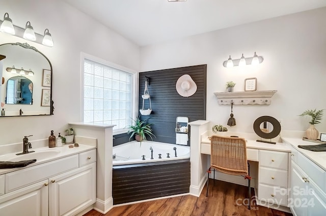 bathroom with vanity, hardwood / wood-style flooring, and a washtub