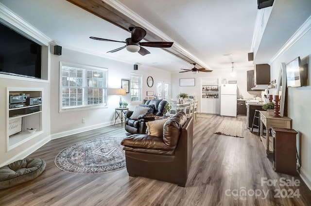 living room with wood-type flooring, beam ceiling, ceiling fan, and crown molding