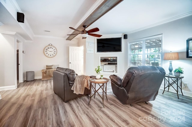 living room featuring light hardwood / wood-style flooring, beam ceiling, ceiling fan, and crown molding