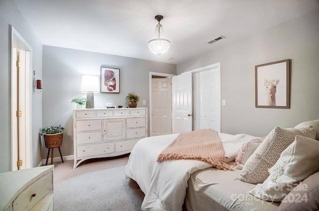 bedroom featuring light carpet and a chandelier