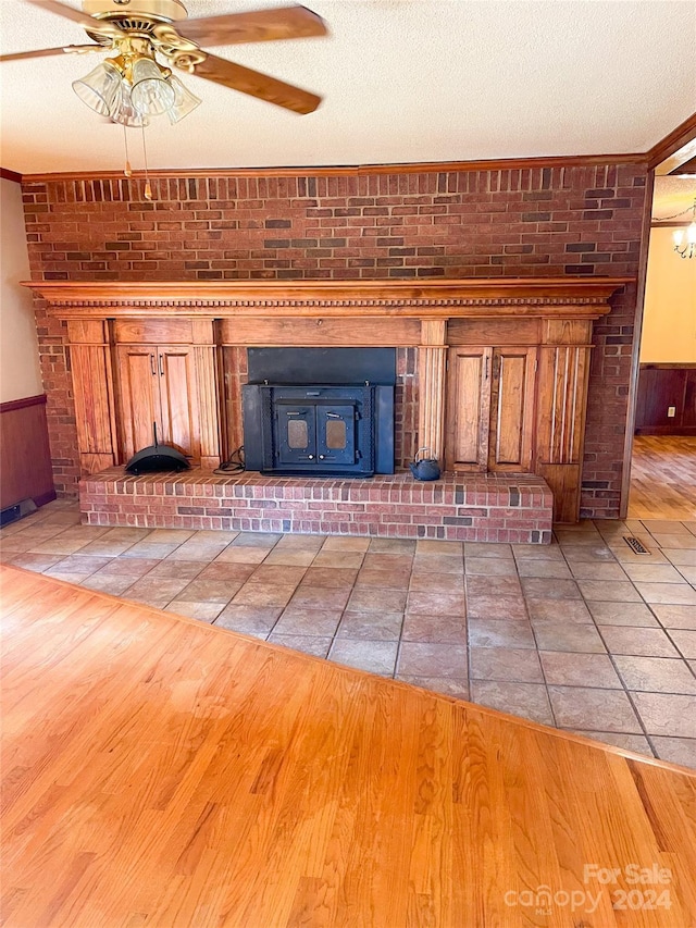 1610 Sierra Rd, York, SC 29745 - unfurnished living room featuring a fireplace, light wood-style floors, a ceiling fan, and a wainscoted wall
