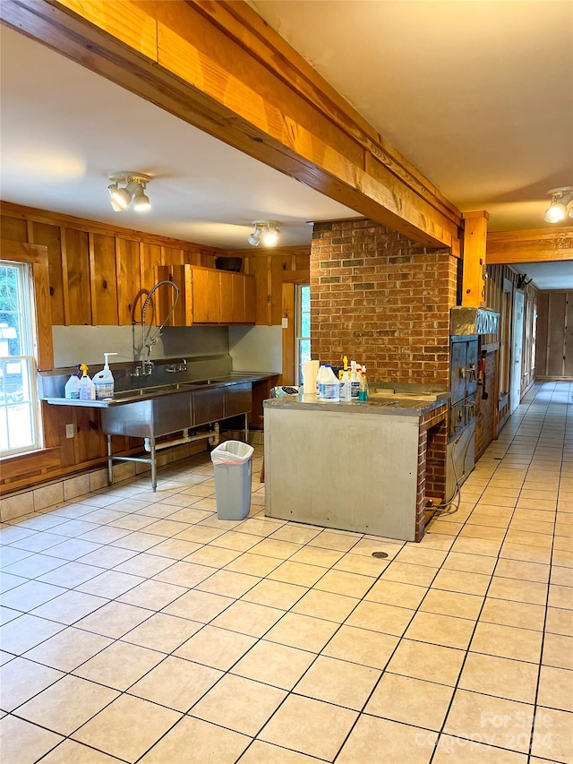 kitchen with wooden walls and light tile patterned floors