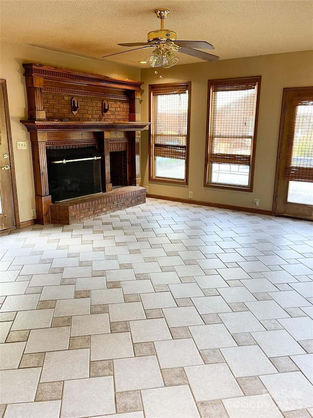 1610 Sierra Rd, York, SC 29745 - unfurnished living room featuring ceiling fan, baseboards, a brick fireplace, and a textured ceiling